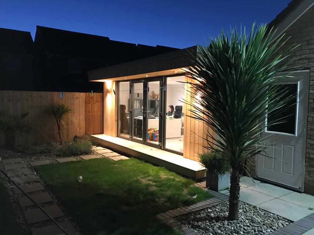 insulated garden office with lights in the evening